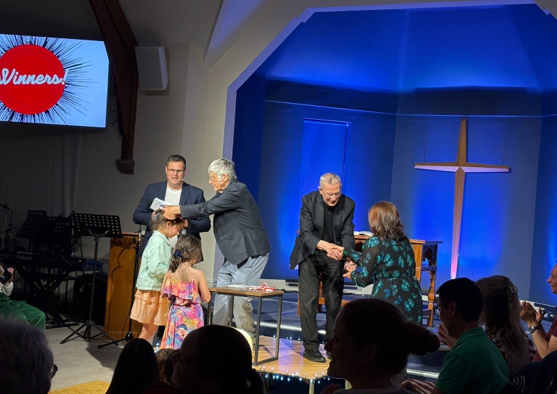 Prize-giving at the poetry slam - 3 winners receive handshakes on stage
