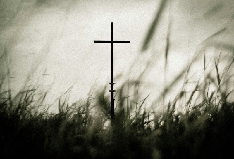 A Christian cross in grass, set against a white background