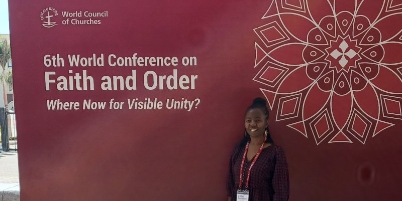 Gale Richards in front sign stating the Faith and Order World Conference