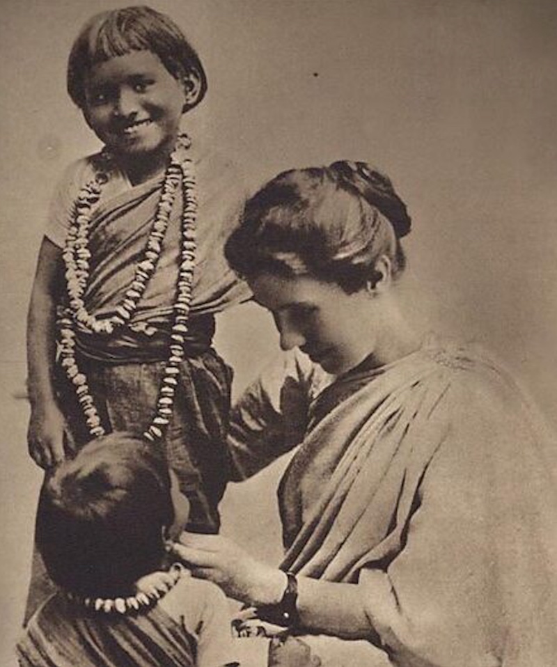 Amy Carmichael smiling tending to 2 young Indian girls 