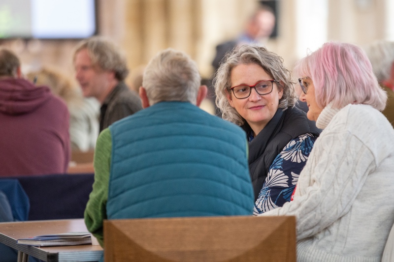 Two women and a man chat and listen to each other around a table at the LoveRural conference