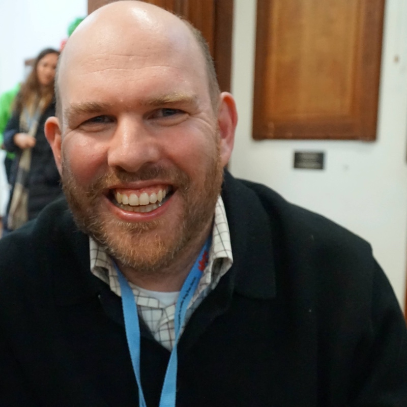Kris McDonald Hope UK 2026 - A close-up headshot of Kris smiling warmly, wearing a lanyard around his neck